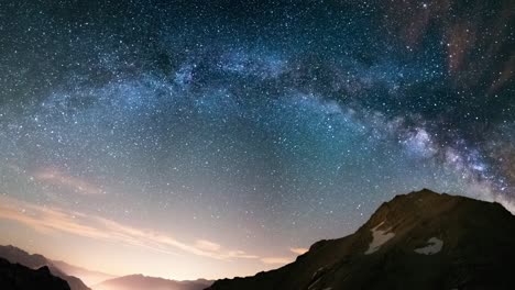 milky way arch and starry sky on the alps. panoramic view, astro photography, stargazing. light pollution in the valley below.