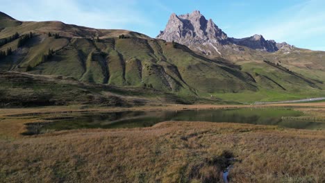 panoramic shot of the green hilly grass fields and hill summits in the distance