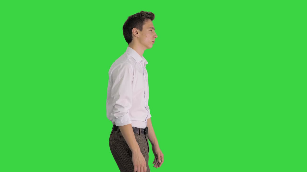 Young businessman in white shirt starts walking on a Green Screen, Chroma Key