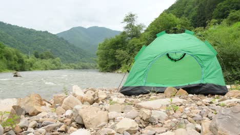 green camping tent on white background a green camping tent with a simple design featuring two windows and red poles for support the tent is set against a plain white background emphasizing its structure and color