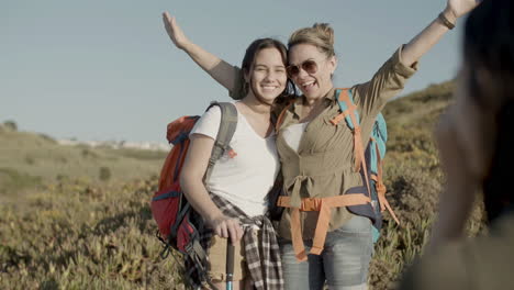 mother and daughter posing making photo, smiling and raising hands