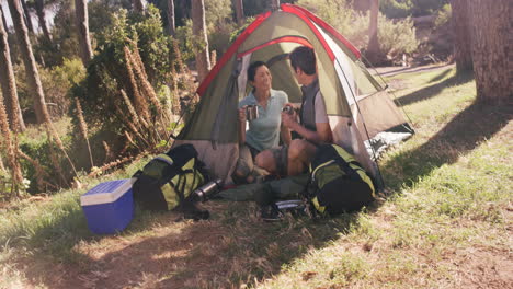 happy couple having cup of coffee in tent