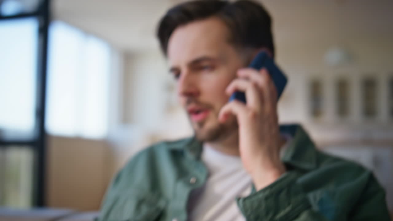 Closeup exhausted businessman calling cellphone at home weekend. Guy talking