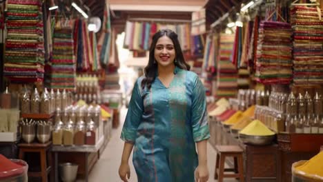 happy indian woman smiling while walking in a spice market