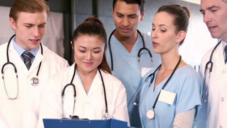 medical team talking together while looking clipboard