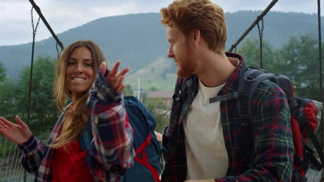 happy couple dancing nature on mountain bridge. lovers having fun on hitchhike.