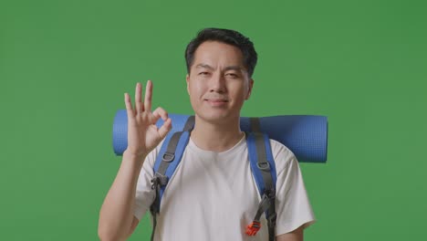 man with backpack giving ok sign