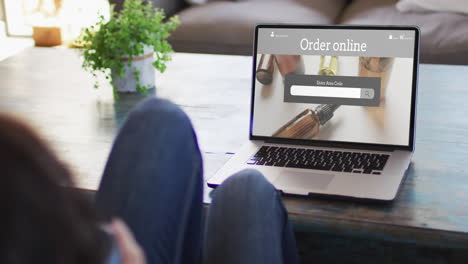 woman at table using laptop, online shopping for beauty products, slow motion