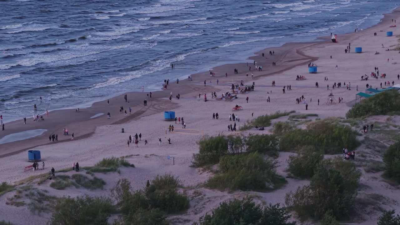 Besøgende forlader Vakarbulli Strand, Riga, efter en delvis solformørkelse ved skumringstid.