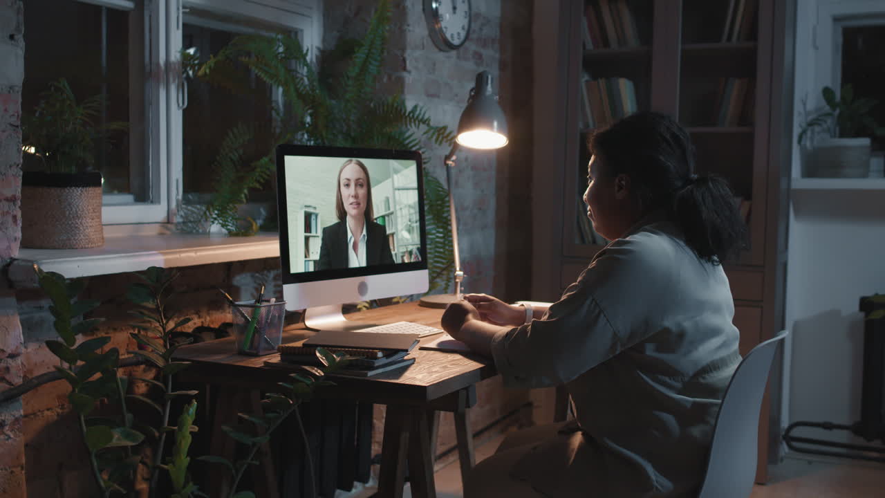 Donna in videochiamata di notte nel suo home office