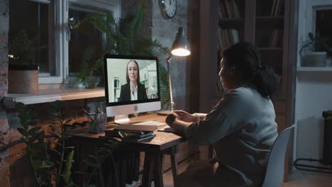 woman having a video call at night in her home office
