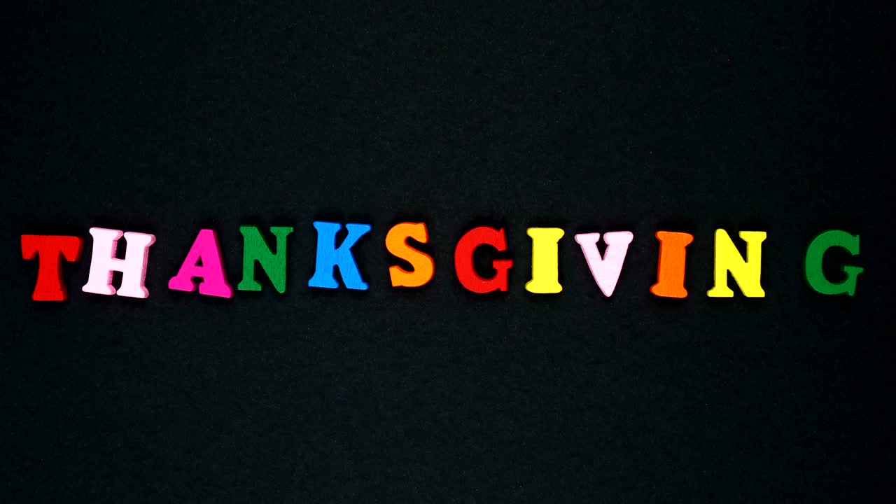 La parola "thanksgiving" formata da lettere di legno multicolori. Parole colorate in loop.