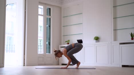 woman doing yoga on mat in spacious room