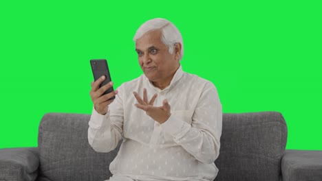 Happy-Indian-old-man-talking-on-video-call-Green-screen