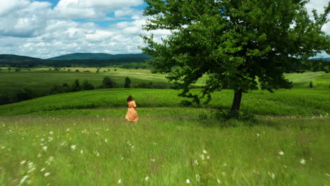 Chica-Con-Vestido-Naranja-En-La-Pradera-De-La-Región-De-Lika,-Croacia