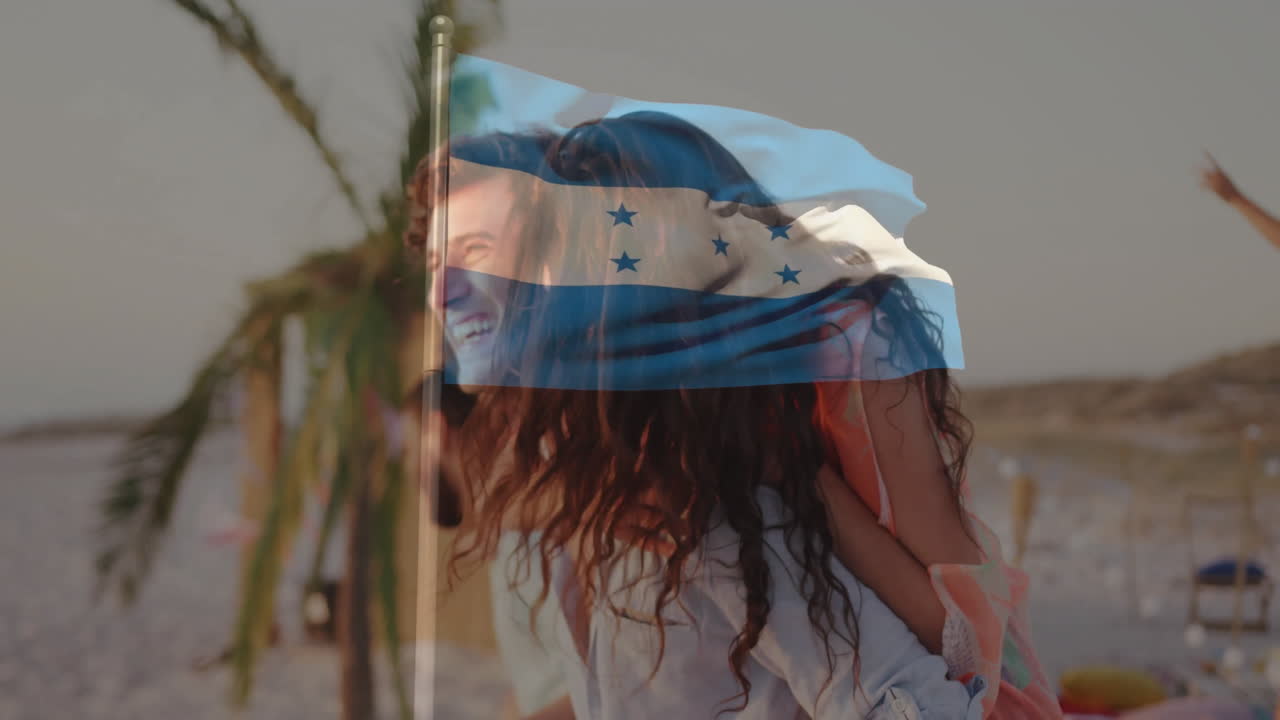 At beach, couple smiling with Honduras flag animation overlaying scene