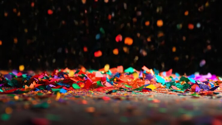 Un'affascinante immagine di coriandoli colorati su sfondo scuro, che celebra la gioia e la festa in tonalità vivaci, scintillanti e riflettenti la luce in una splendida composizione