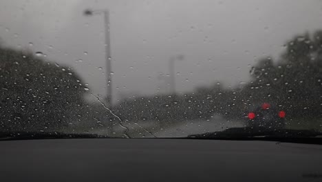 Camión-Moviéndose-En-La-Autopista-Bajo-La-Lluvia,-Toma-Amplia-Con-Fondo-Borroso,-Parabrisas-Bajo-La-Lluvia