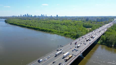 Aerial-view-of-traffic-moving-on-a-massive-bridge-over-the-Vistula-River-in-Warsaw