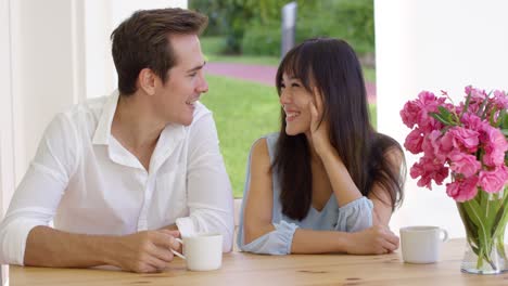 laughing young adult couple sitting at table