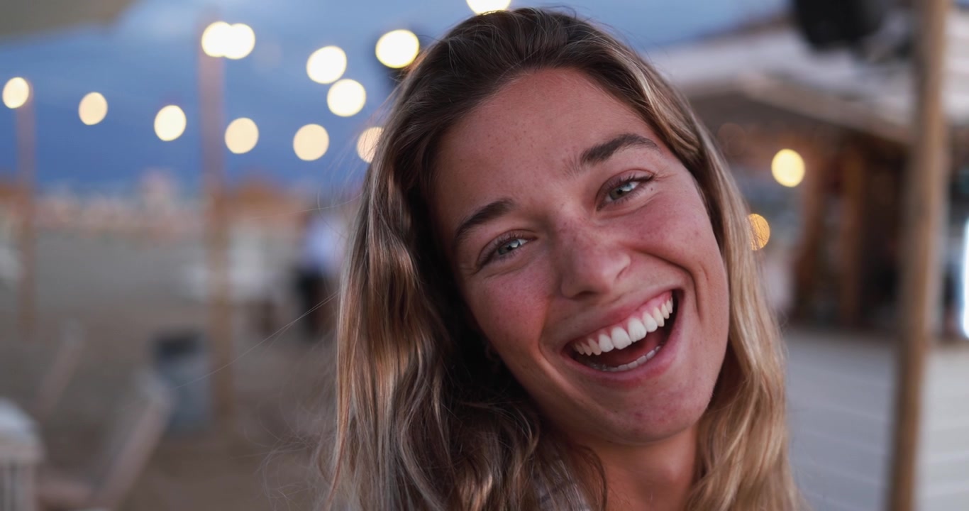 Close-up de Jovem Mulher Feliz Rindo ao Ar Livre à Noite
