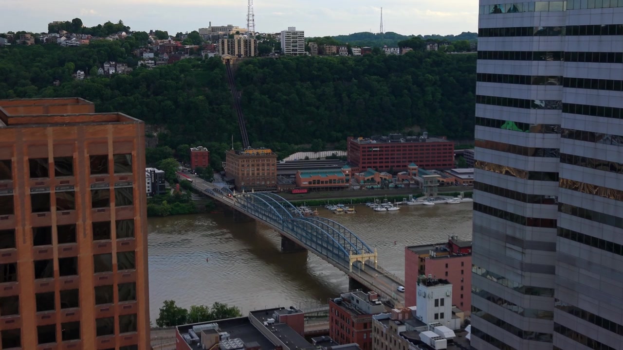 Vista aerea con drone incorniciata tra i grattacieli della città, che guarda verso il fiume e lo skyline di Pittsburgh, Pennsylvania.