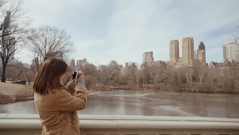 woman photographing central park in winter