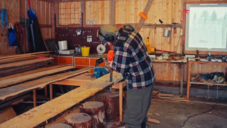 man doing woodwork inside barn house - medium shot
