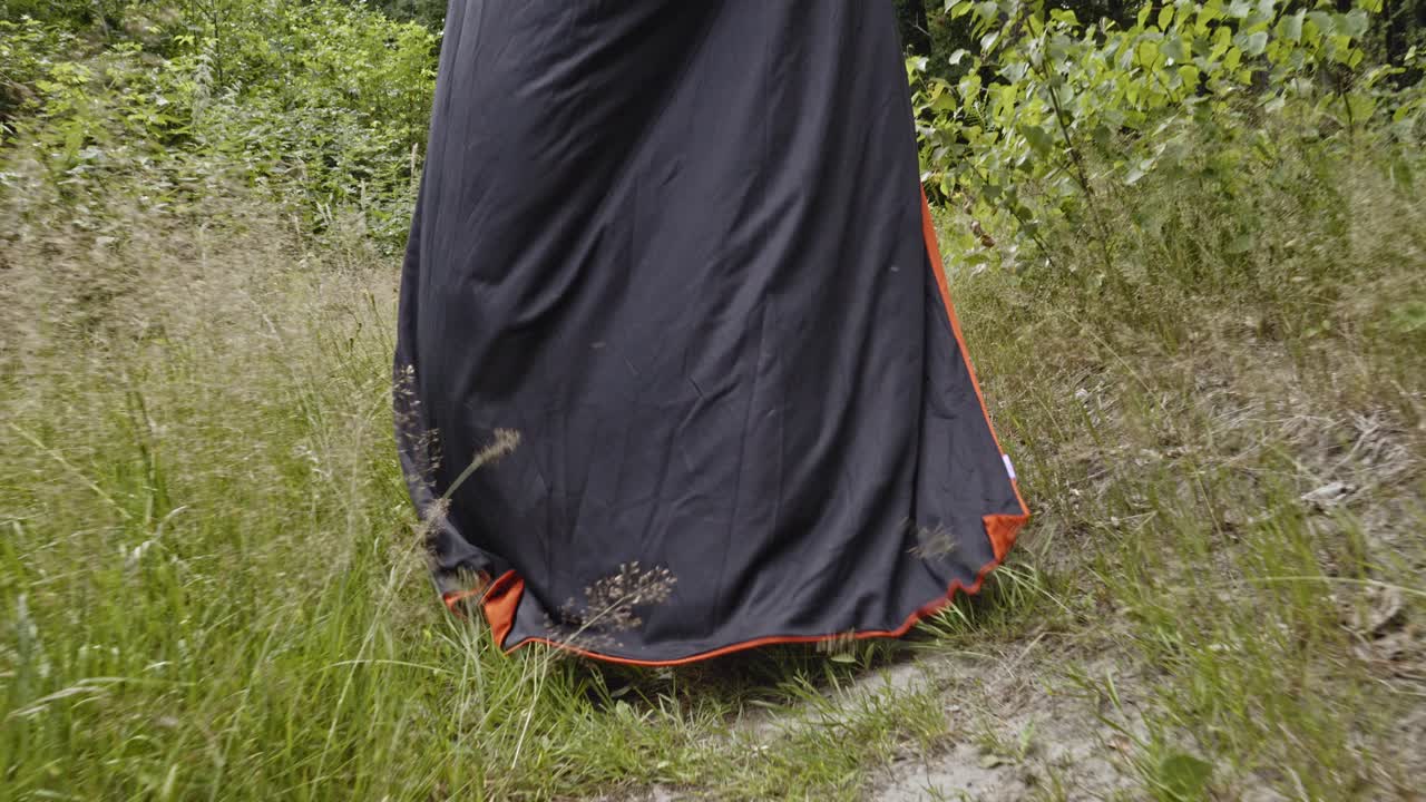 잔인 사신의 검은 망토가 풀이 무성한 숲에서 걷고 있다