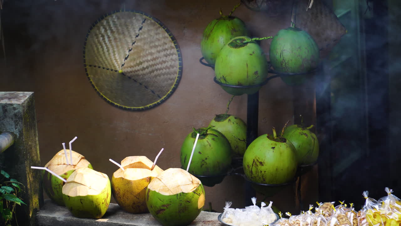 jugo de coco fresco y sombrero indonesio, vista de mano