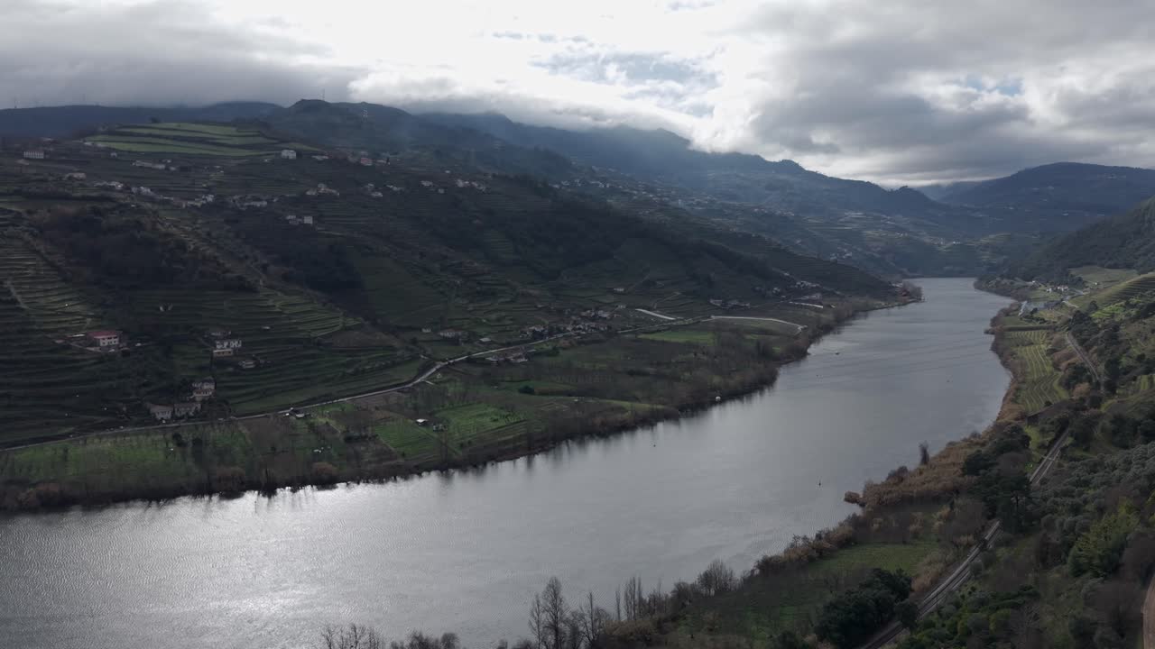 Paesaggio dei vigneti terrazzati della valle del Douro lungo il fiume Douro sotto il cielo nuvoloso, ripresa aerea