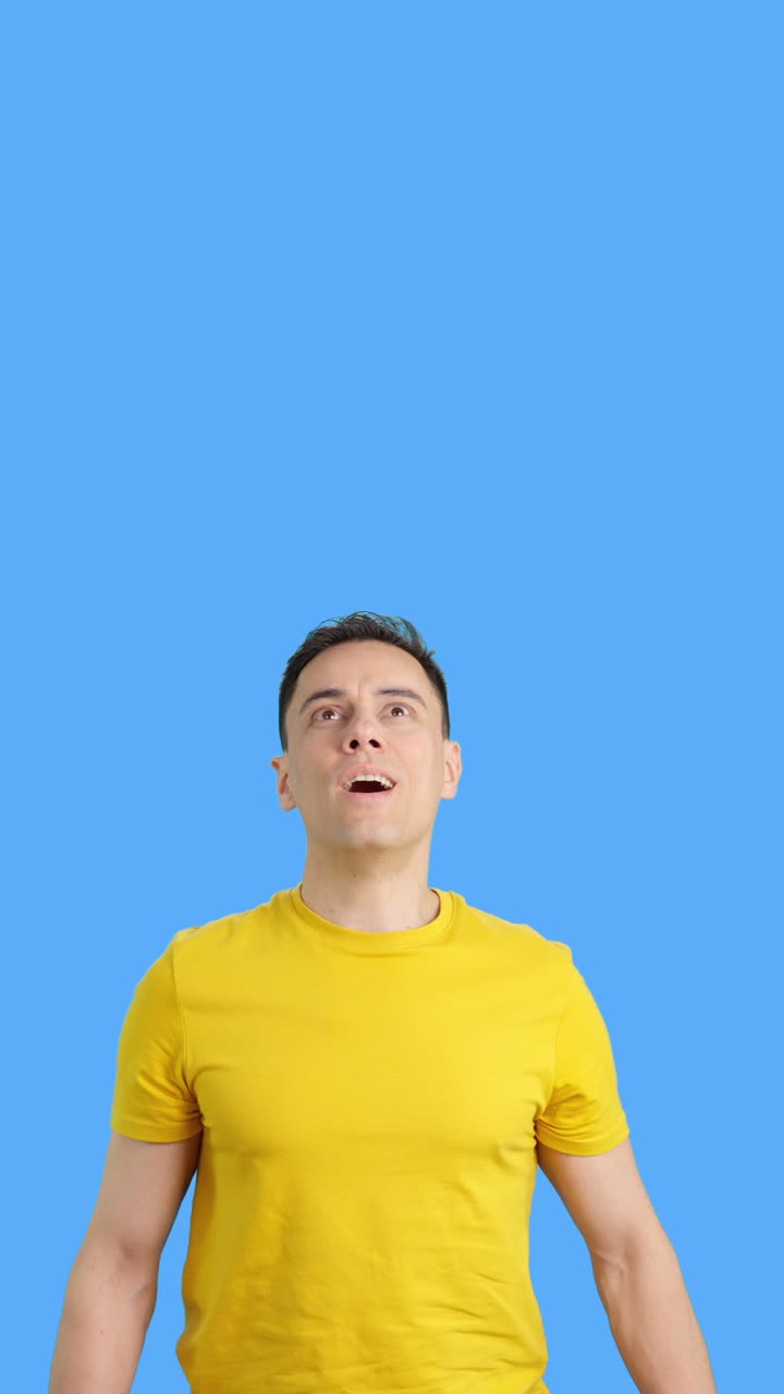 Man in yellow t-shirt with surprised expression