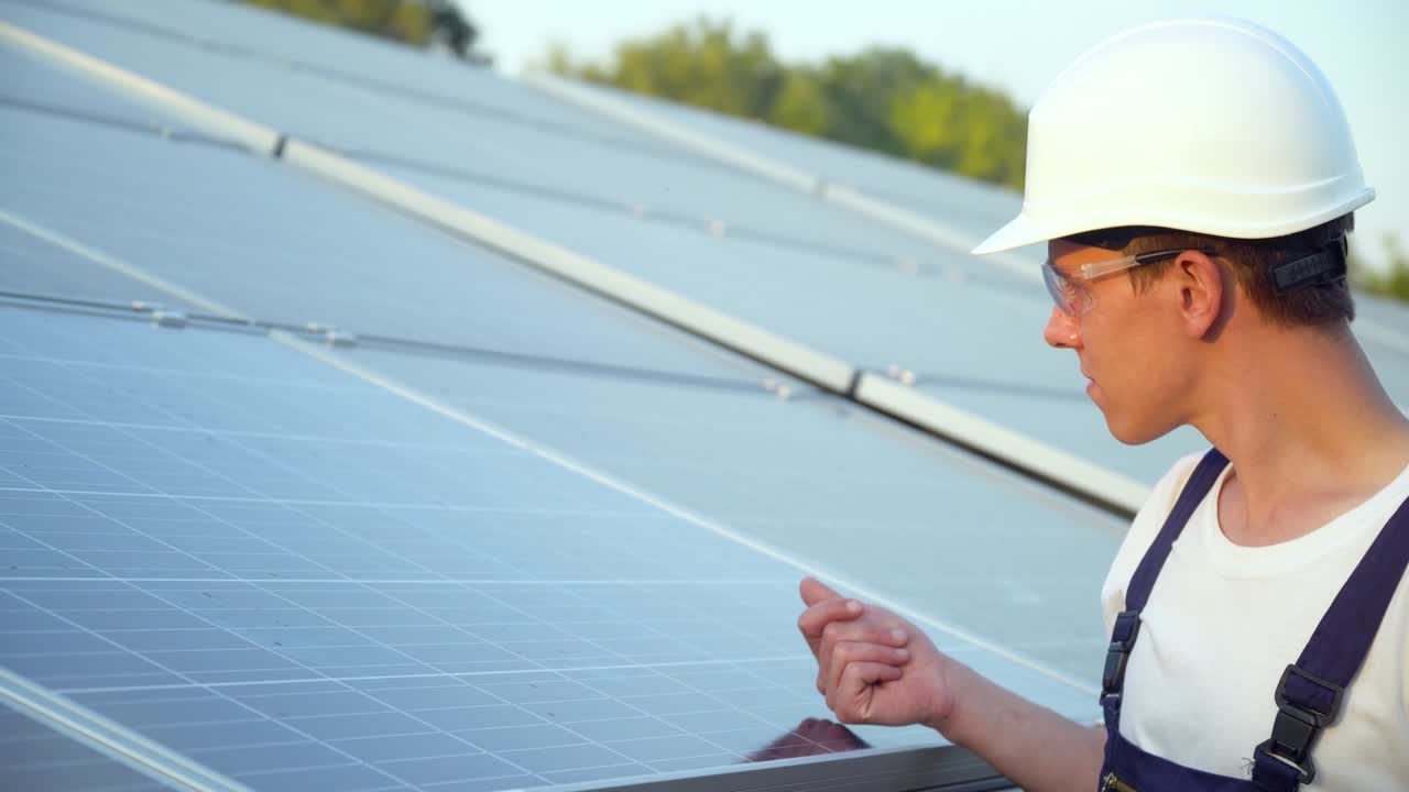 Young engineer is checking the operation of sun and cleanliness of photovoltaic solar panels. Concept renewable energy