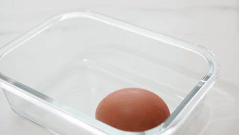 close up male hand taking brown eggs out of the carton