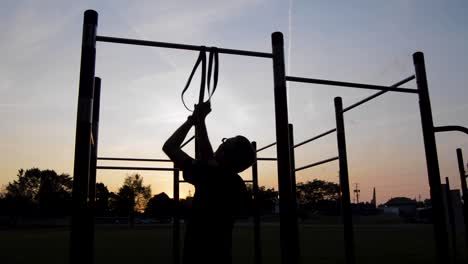 Young-Male-Putting-Resistance-Band-on-Bar-in-Early-Morning