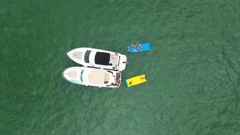 two yacht boats with people enjoying summer vacation in miami, florida - aerial view directly above