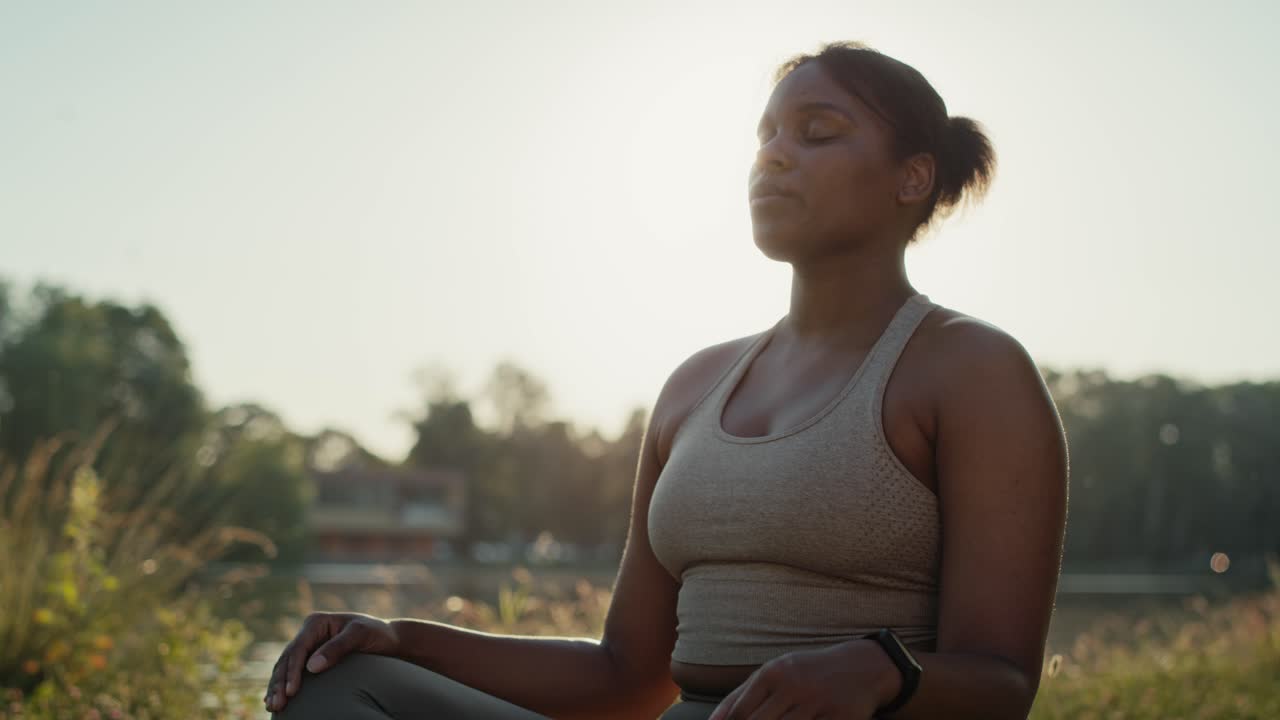 mujer practicando ejercicios de respiración en el parque en un día de verano.