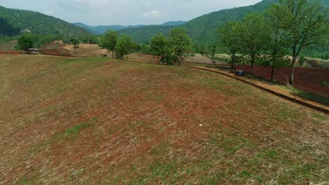 Vista-Aérea-De-Un-Tranquilo-Pueblo-Rural-En-Tailandia-Rodeado-De-Montañas-Y-árboles.