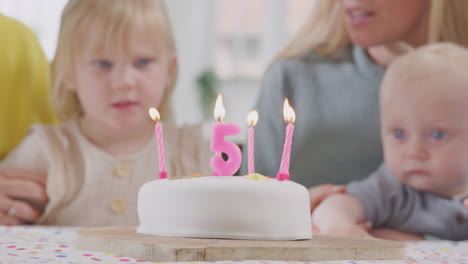 Grandparents-With-Mother-And-Grandchildren-Celebrating-With-Fifth-Birthday-Party-At-Home