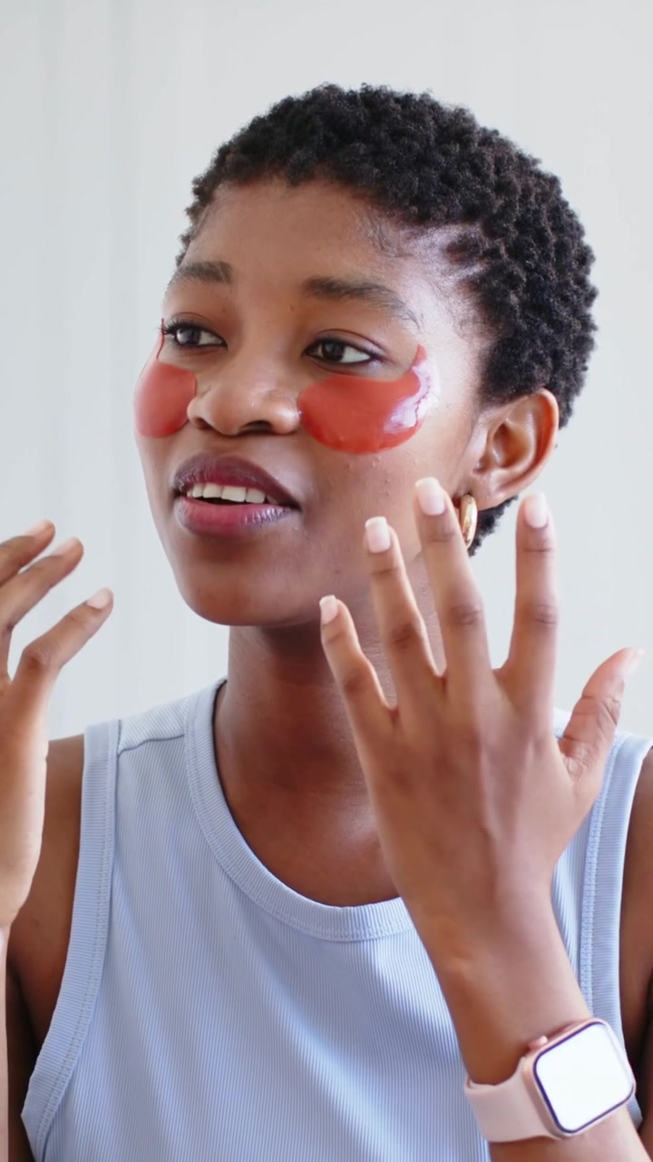 Vertical video: Woman in blue top fixing red patches reacting to hands entering at home, copy space