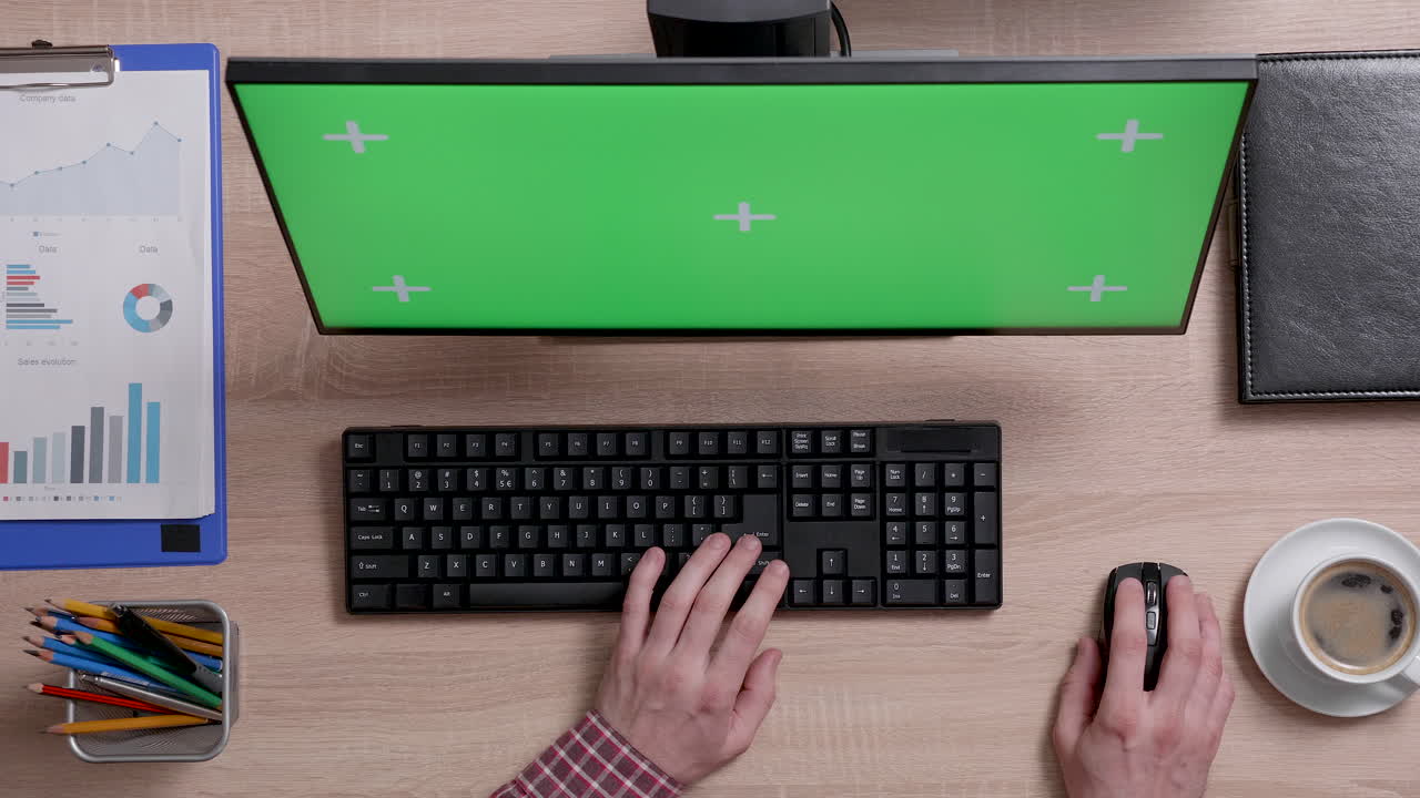 Workplace with computer and green screen