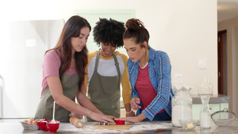 women friends baking cookies together in kitchen, enjoying festive holiday preparations