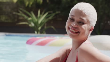 Retrato-De-Una-Mujer-Birracial-Feliz-En-La-Piscina-En-Cámara-Lenta