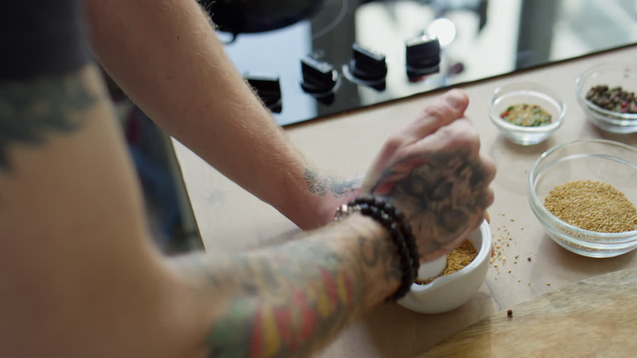 Man Grinding Sesame Seeds in Mortar with Pestle