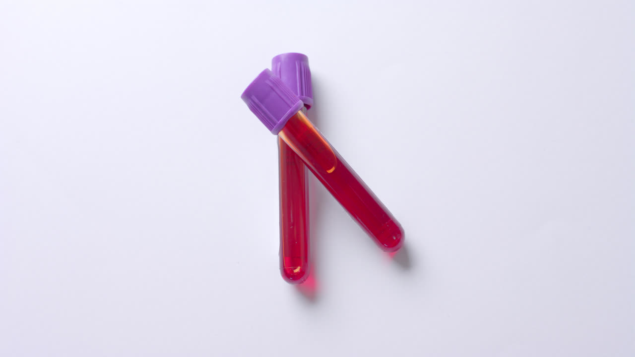 Close up of blood samples on white background with copy space, slow motion