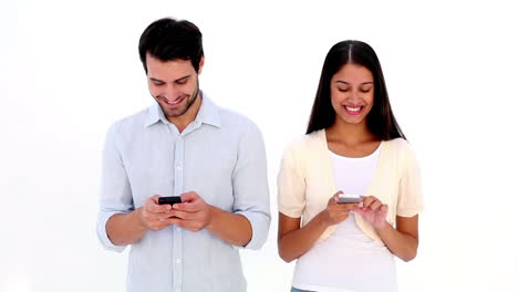 Attractive-young-couple-texting-on-phones