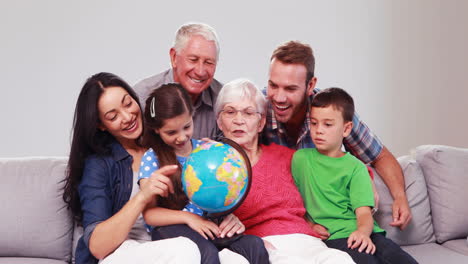 Focused-extended-family-looking-at-globe