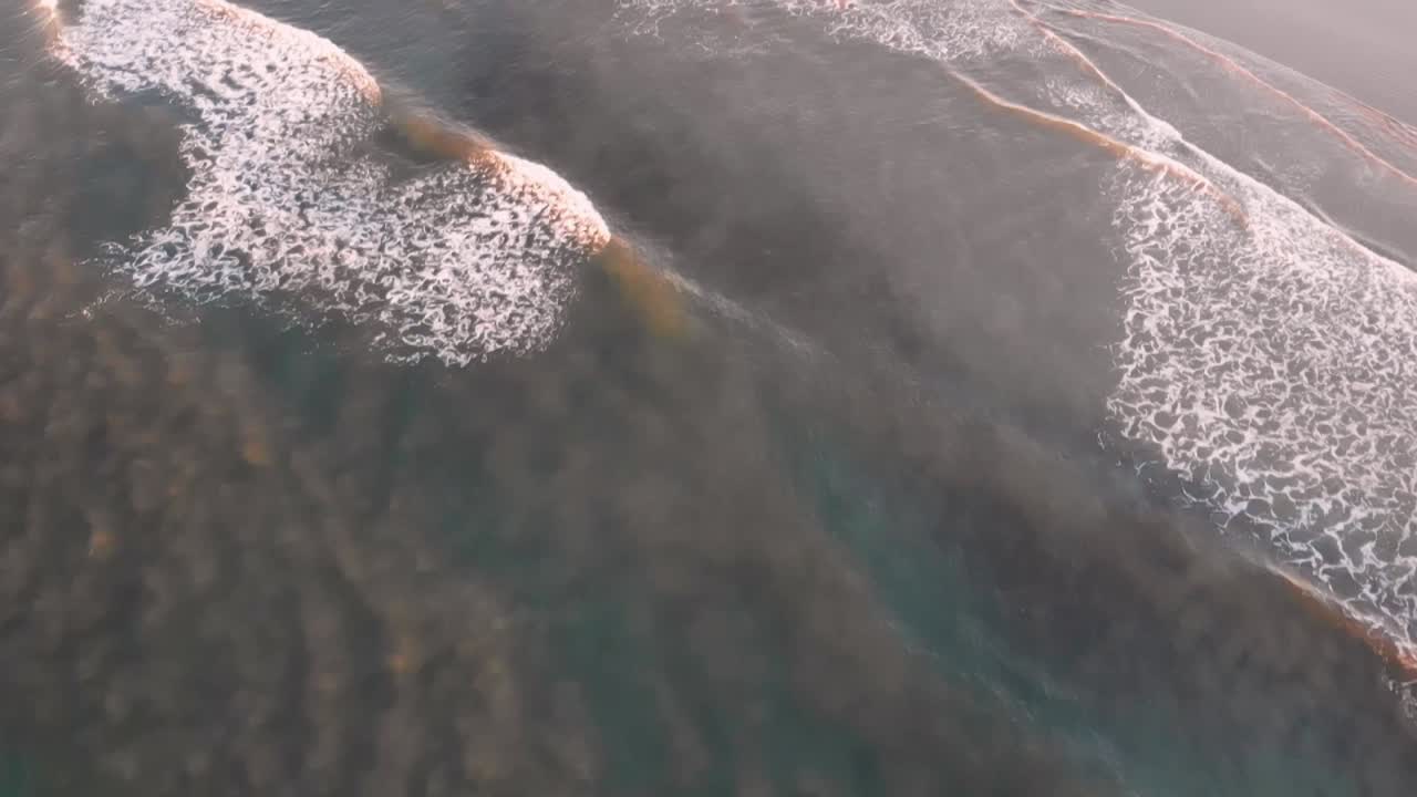 esta toma consiste en un dron que mira las olas y se desplaza lentamente hacia la playa