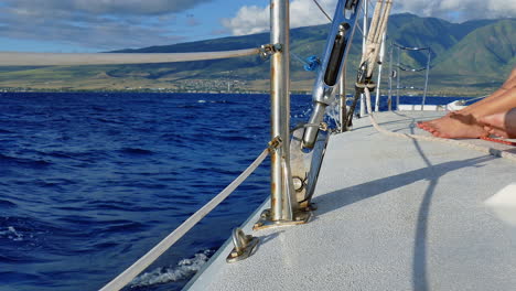 this is 4k video of people's feet on a sailboat sailing off the coast of maui hawaii