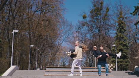 positive friends having fun in the park in autumn. teenage boys and a girl enjoy the time together outdoors. happy youth lifestyle.